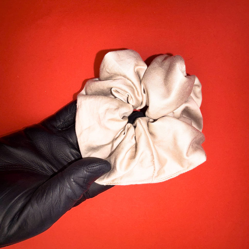 Béžově zlatá Scrunchie Classic od Hecatoo™ v ruce – teplý luxusní odstín ze 100% bavlněného saténu. Ručně šitá gumička do vlasů šetrná k vlasům i pokožce, vyrobená v české dílně.