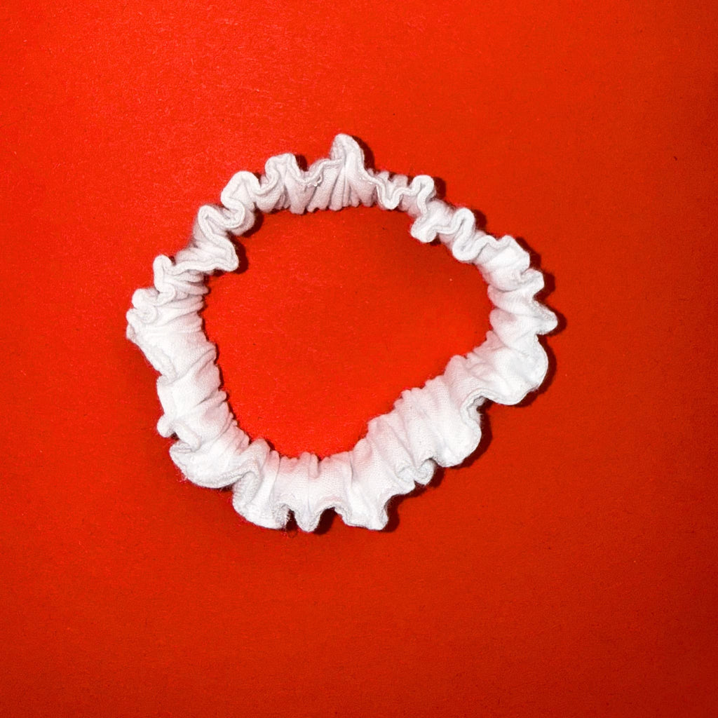 Scrunchie Mini bílá od Hecatoo™ — ručně šitá gumička do vlasů ze 100% bavlněného saténu. Jemná a šetrná k vlasům, vyrobená v české dílně.