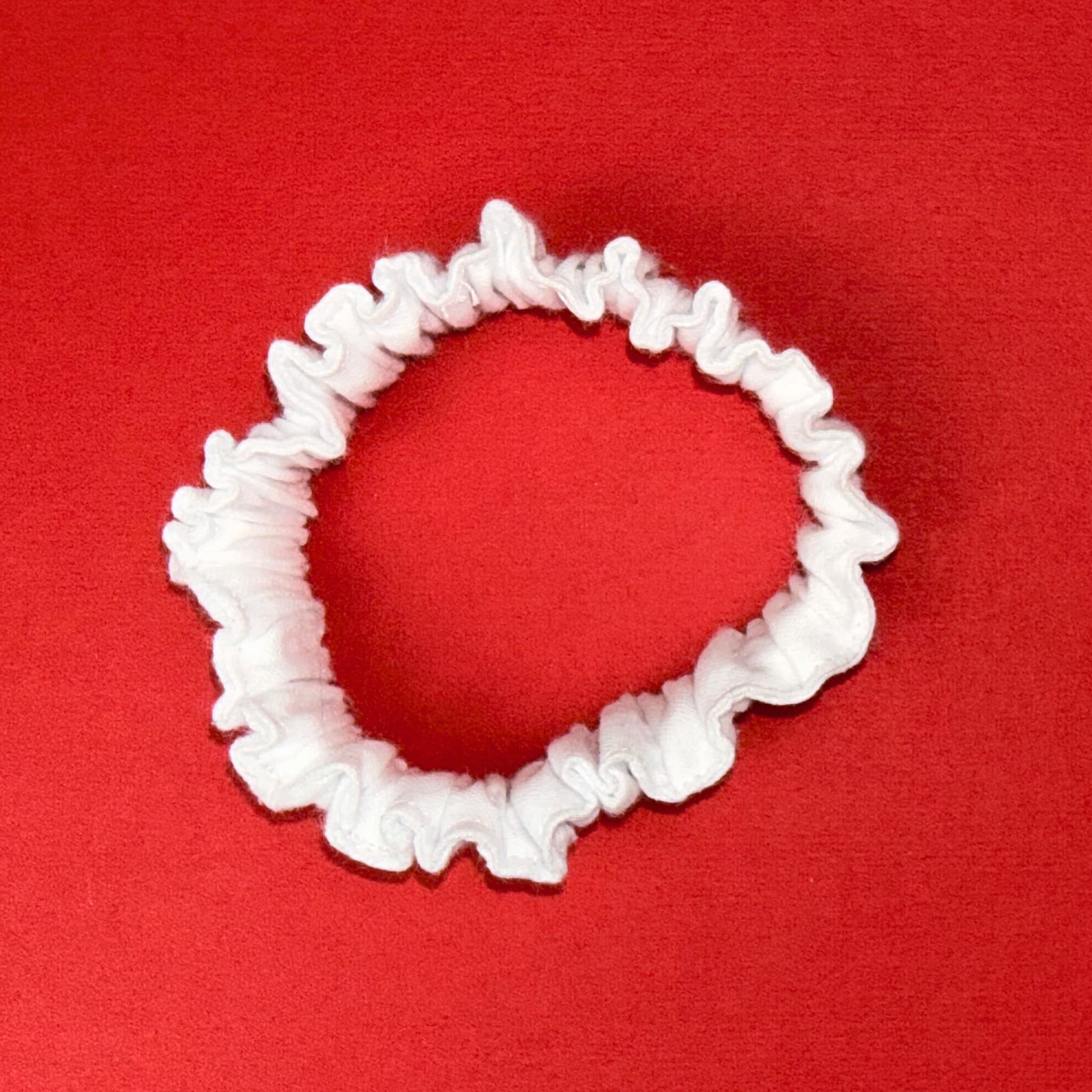 Bílá Scrunchie Mini Hecatoo™ — miniaturní gumička do vlasů z bavlněného saténu bez polyesteru. Ideální pro jemné a tenké vlasy.