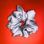 Šedá Scrunchie Oversized od Hecatoo™ v ruce – sofistikovaný minimalismus ve velkém formátu. Handmade gumička ze 100% bavlněného saténu, šetrná k vlasům, bez polyesteru.