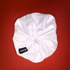 Bílá Scrunchie Oversized Smooth od Hecatoo™ v ruce – elegantní gumička do vlasů ze 100% bavlněného saténu s jemným řasením. Ideální volba pro svatební nebo plesový účes.